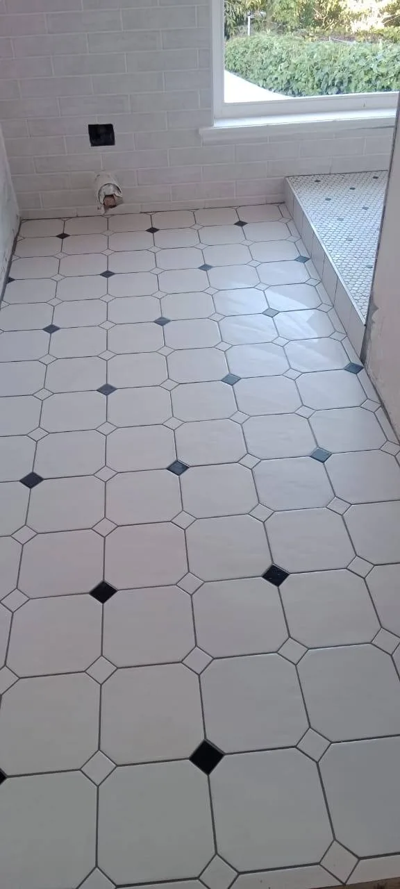 Bathroom floor tiling with white octagon tiles and small dark accent tiles