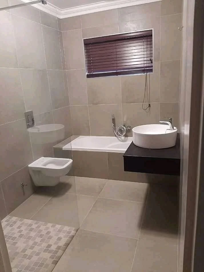 Bathroom wall and floor tiling with straight grout lines and neat edge finishing